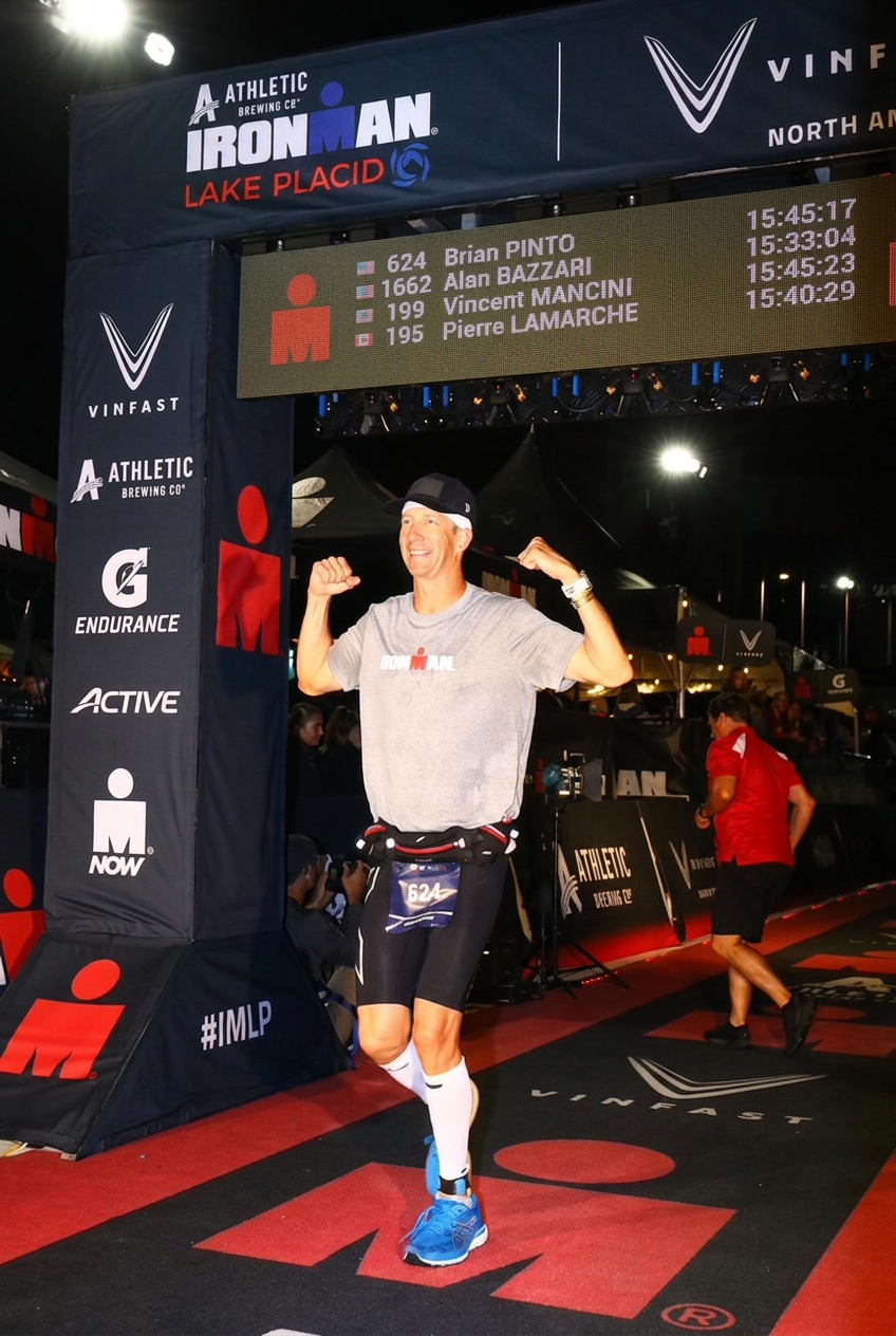 Brian Pinto finishing Ironman Lake Placid in 2023 at the finish line arch